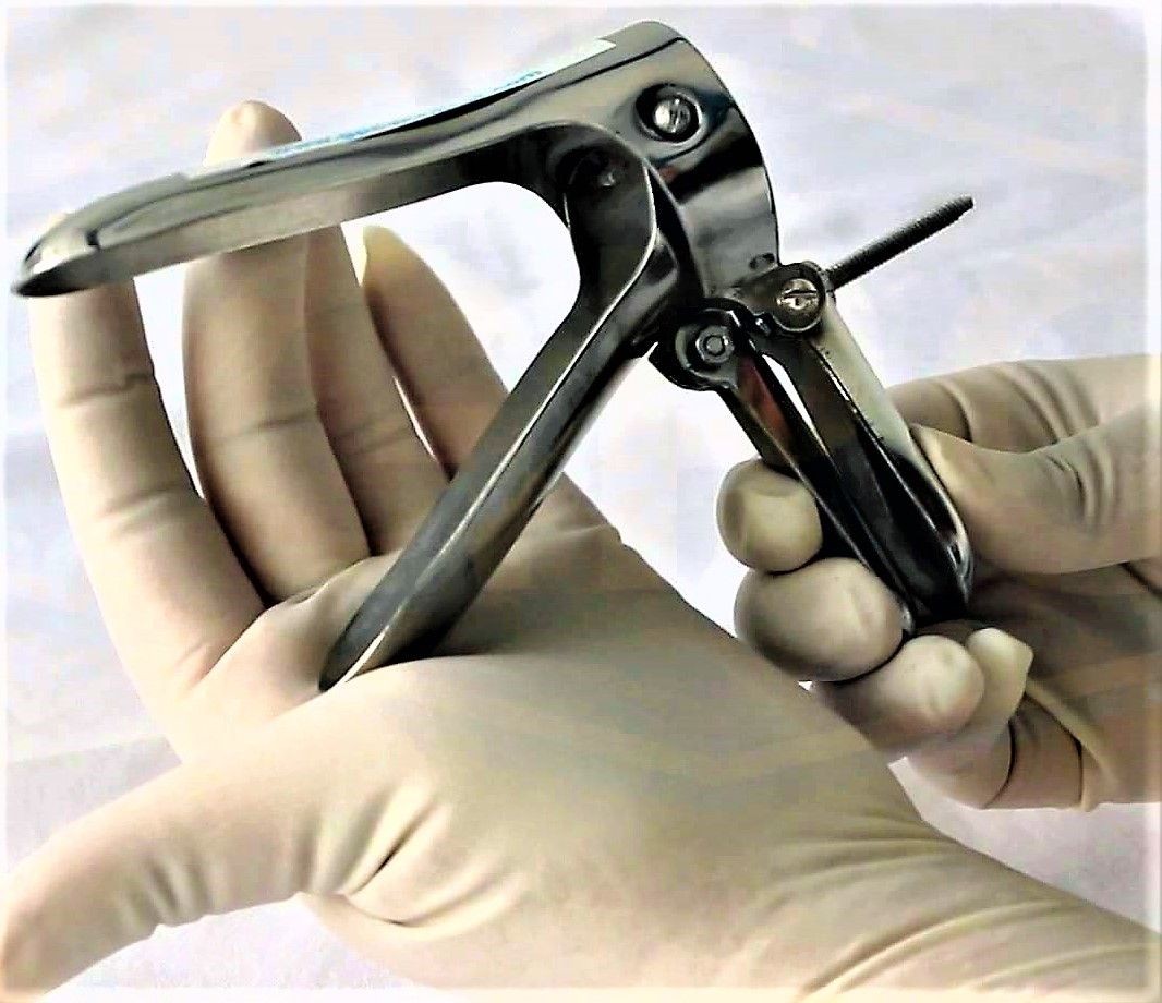 Gloved hands operating a bivalve vaginal speculum